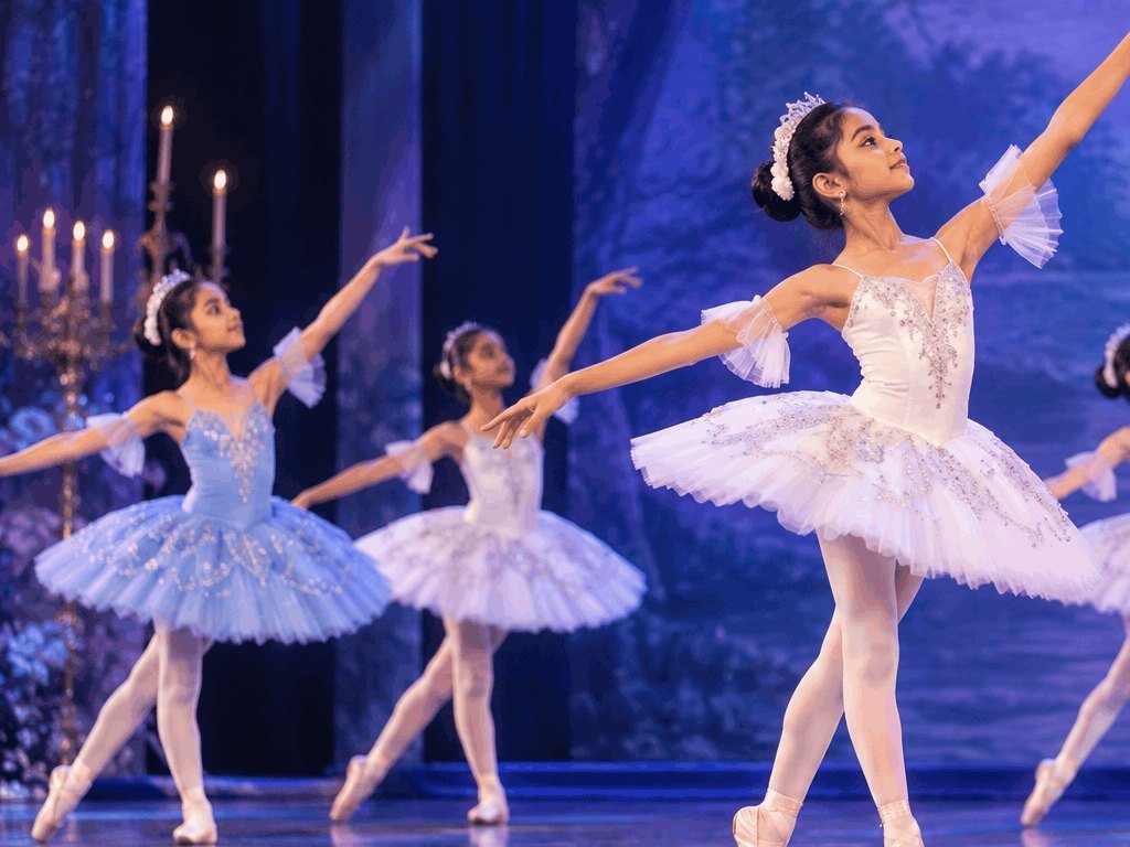 Young ballerinas in pastel tutus dancing on a stage