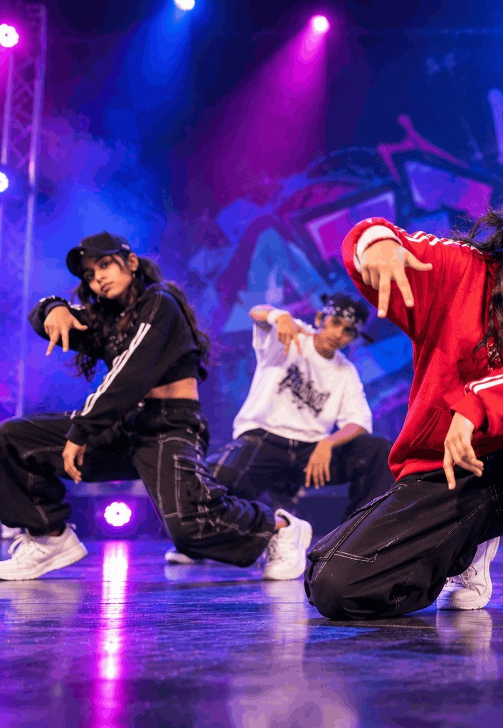 Hip-hop crew dancing under stage lights